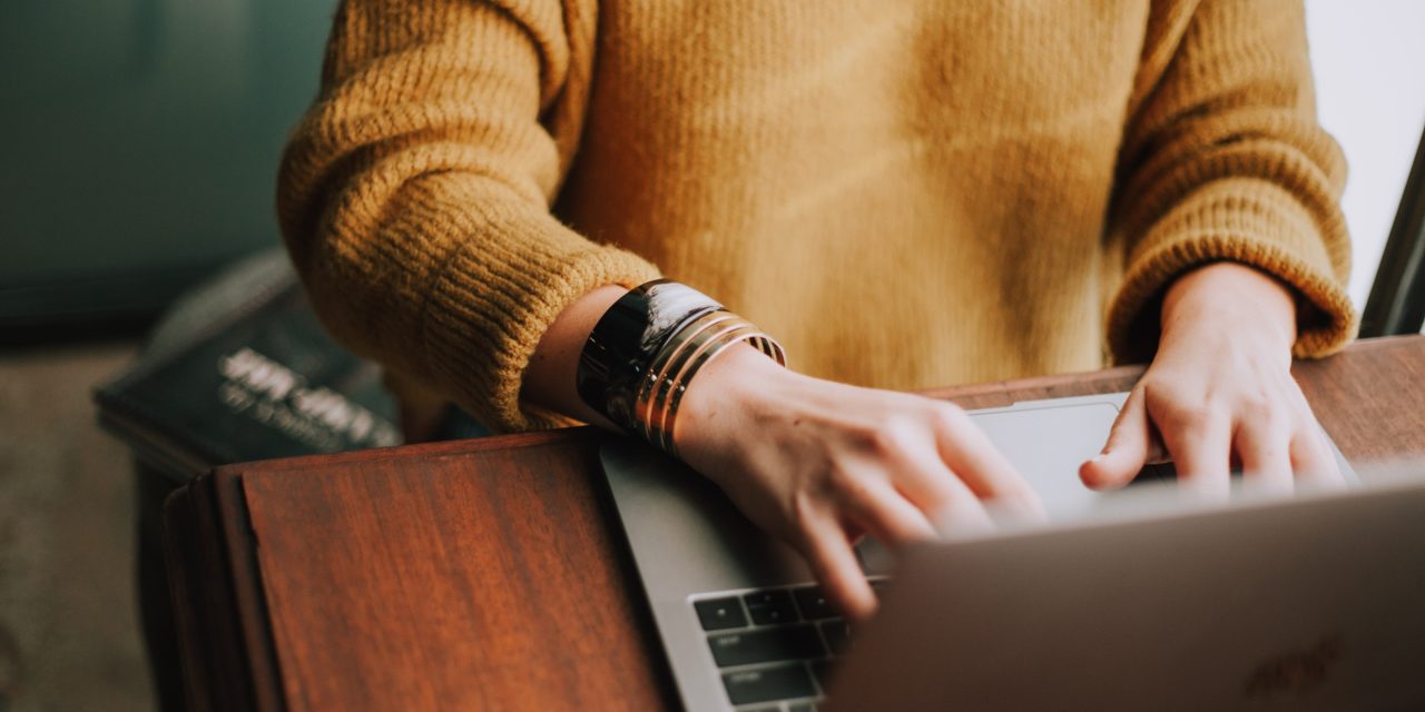 Woman On Computer In Sweater