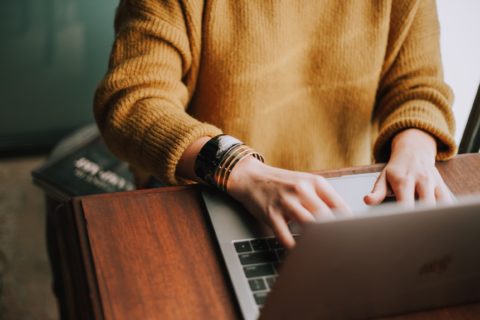 Woman On Computer In Sweater